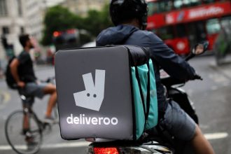 A deliveroo rider prepares to enter traffic