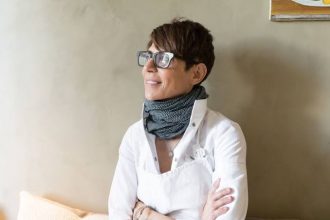 Domonique Crenn wearing a white shirt smiling with head faced to the left