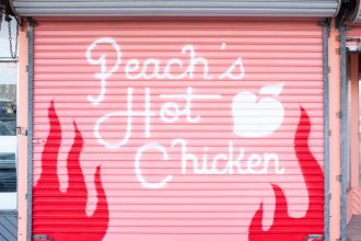 Peach's Hot Chicken text on pink garage door