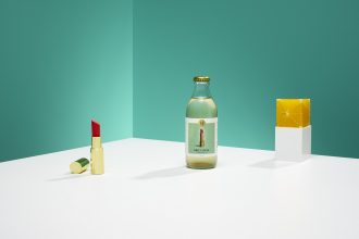 Product shot of StrangeLove mixers with teal background and lipstick as props