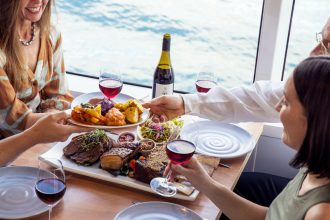People sitting around dinner table with a glass of wine
