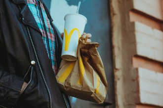 Guy holding McDonald's bag and cup