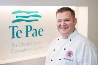 Desmond Davies infront of Te Pae Christchurch logo