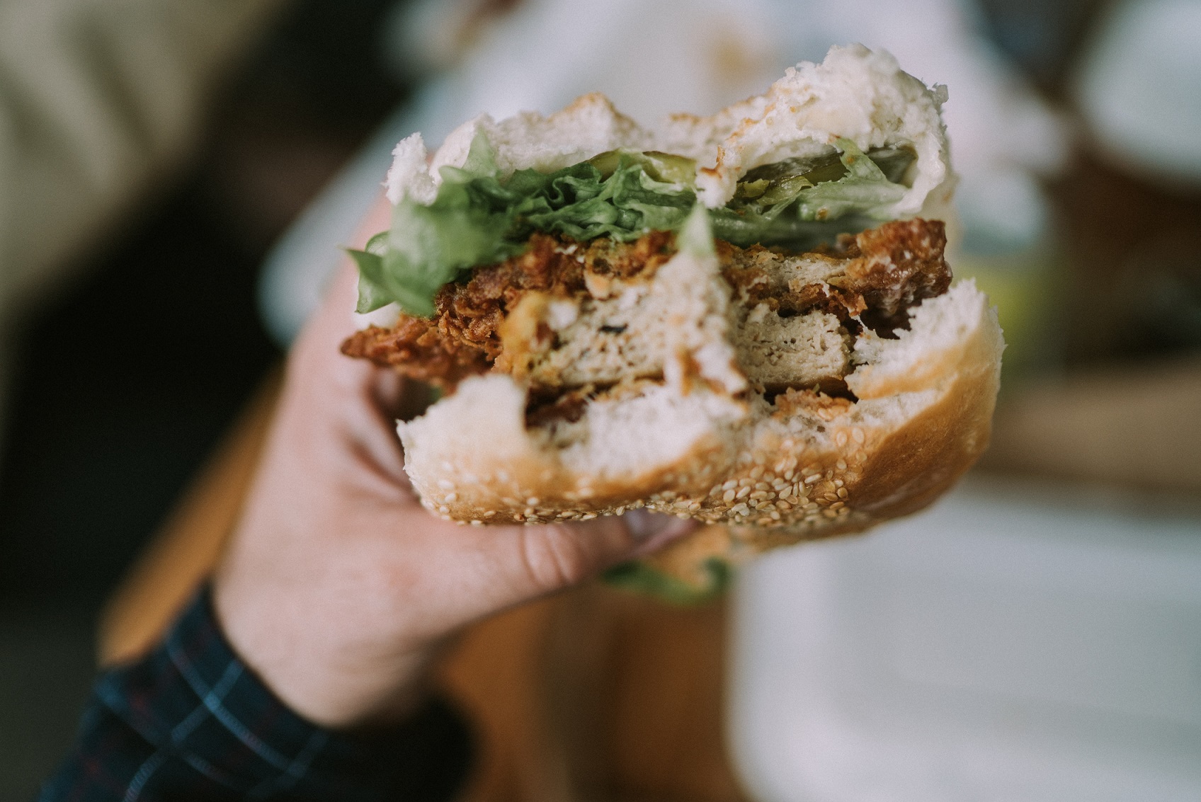 Plant-based chicken with bites held up by hand