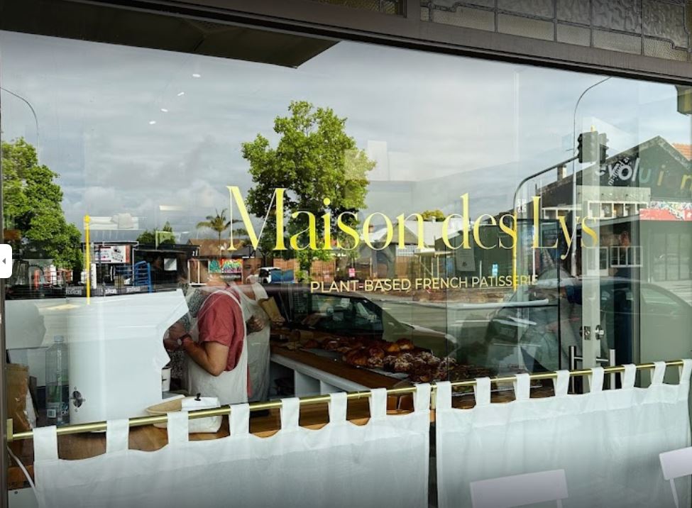 window at bakery Maison De Lys with people in the shop behind window