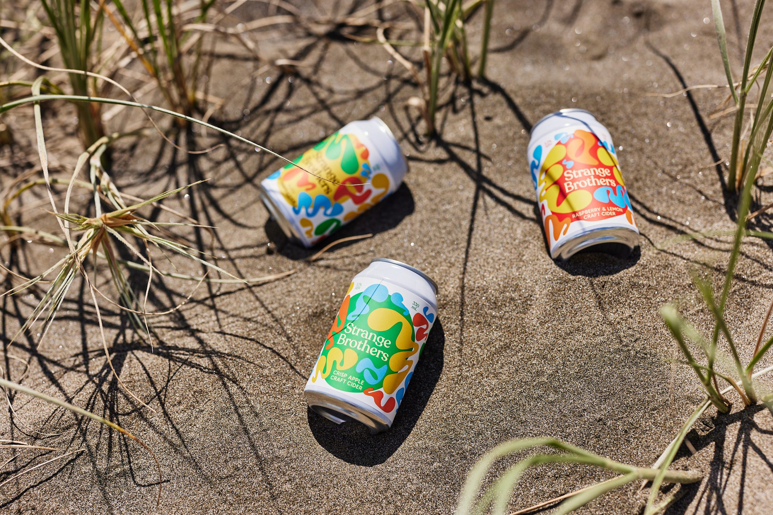 three cans of craft beer on the sand