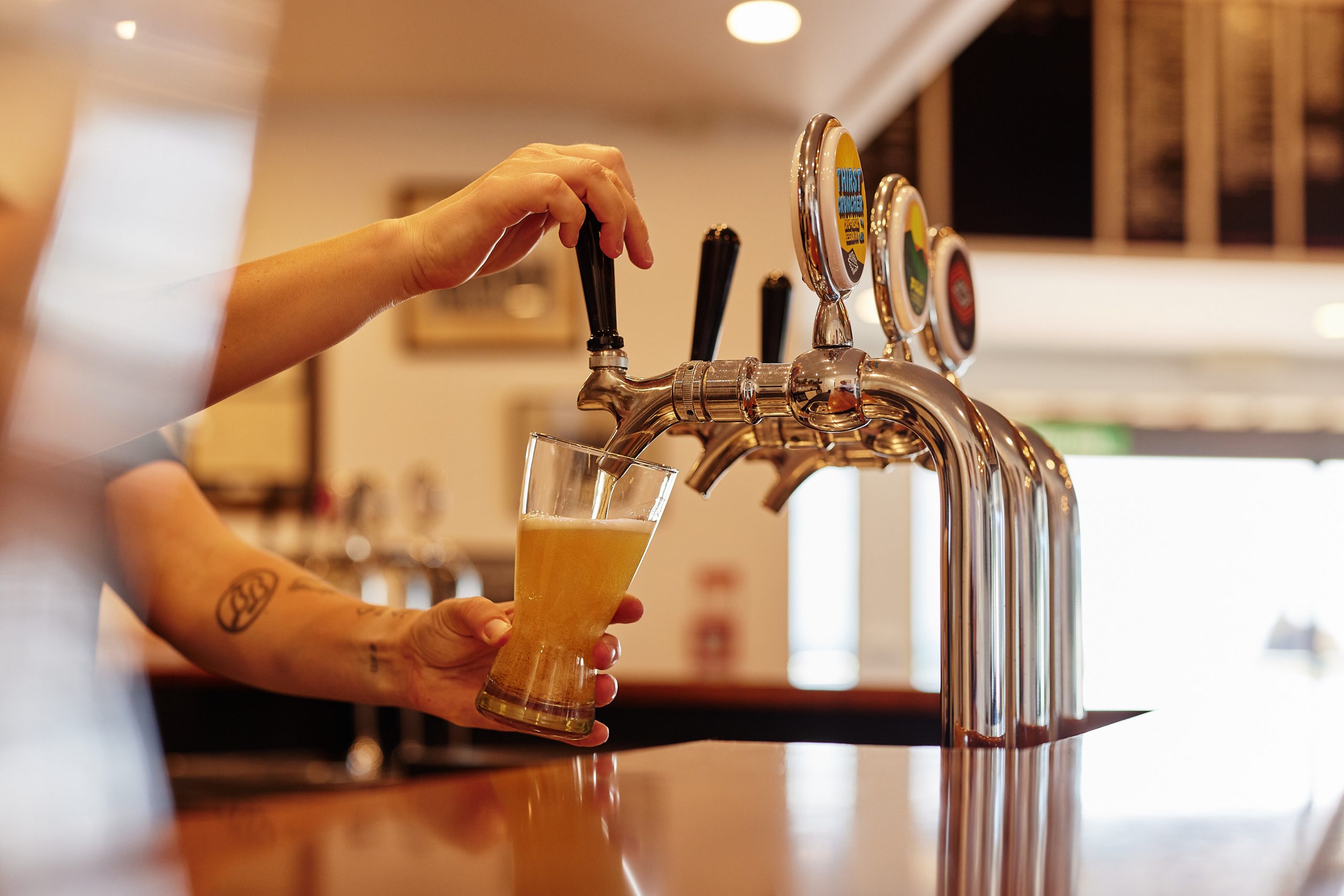 hands pouring a tap beer into glass