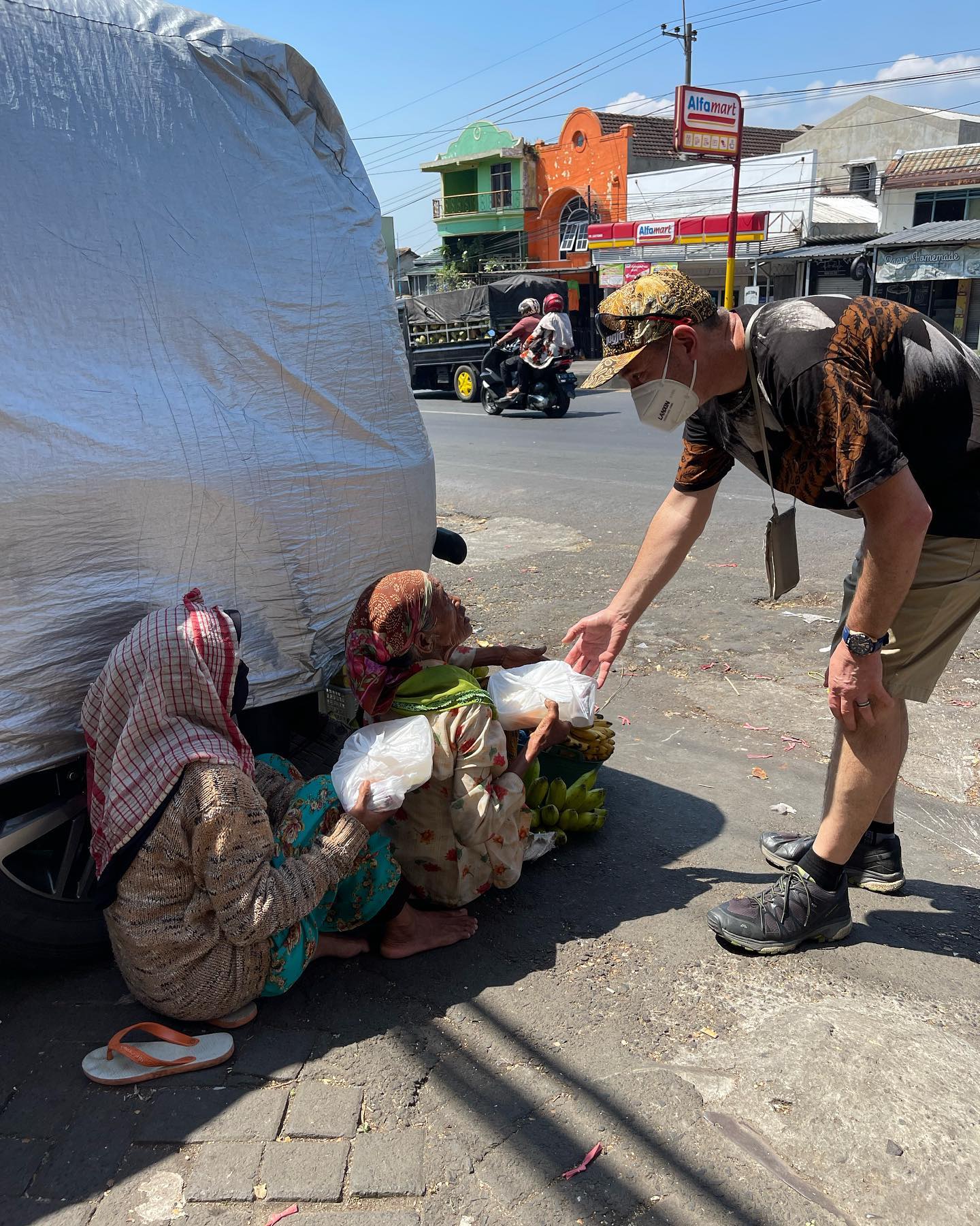 Man reaching over feeding children