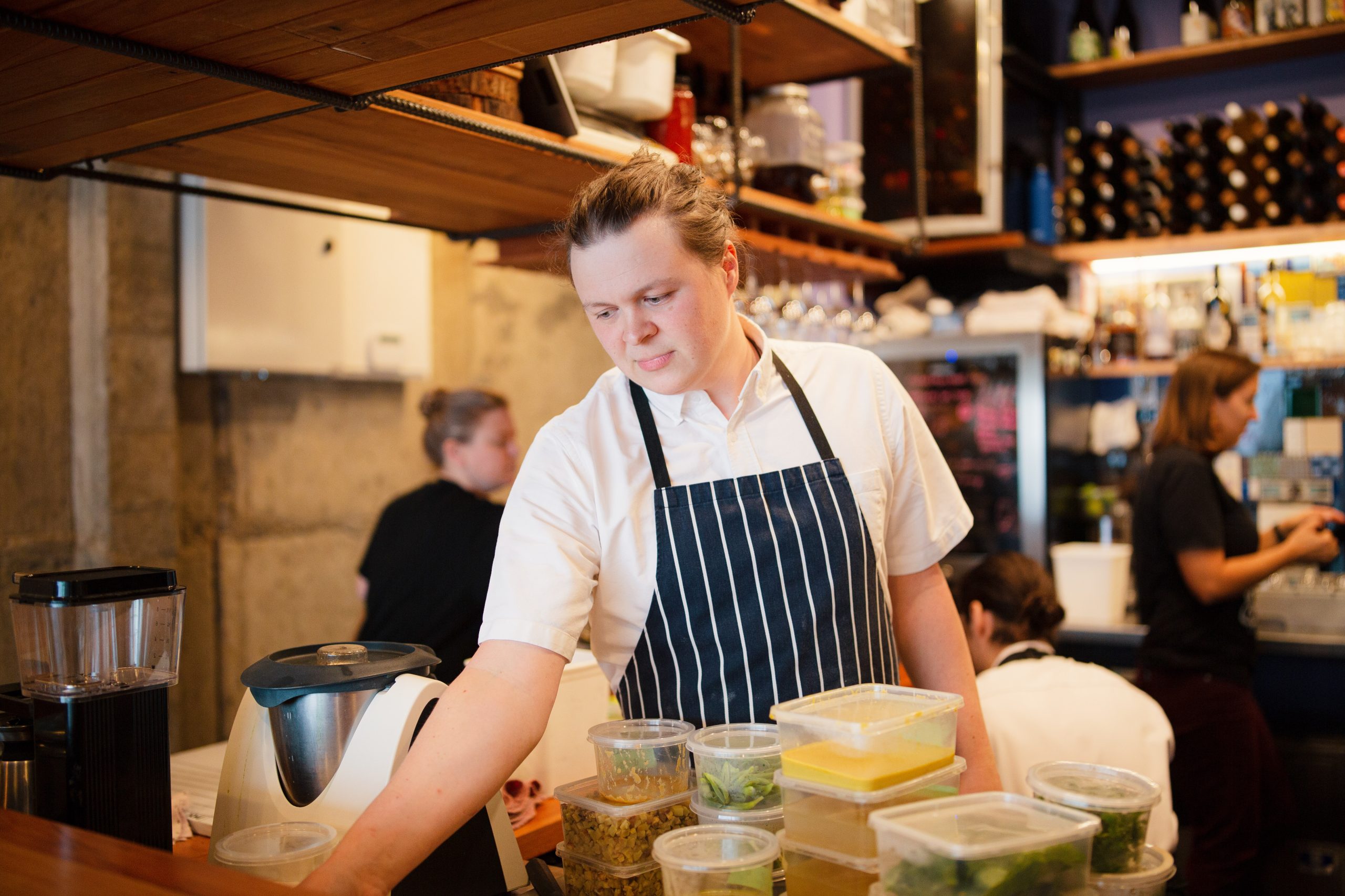 male chef standing in kitchen over food ingredients