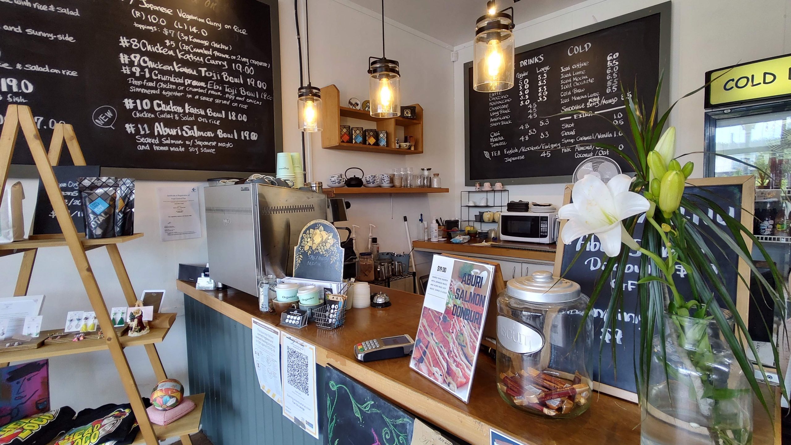 restaurant view Head Loco counter till with lights, sign, menu, flowers in vase on counter