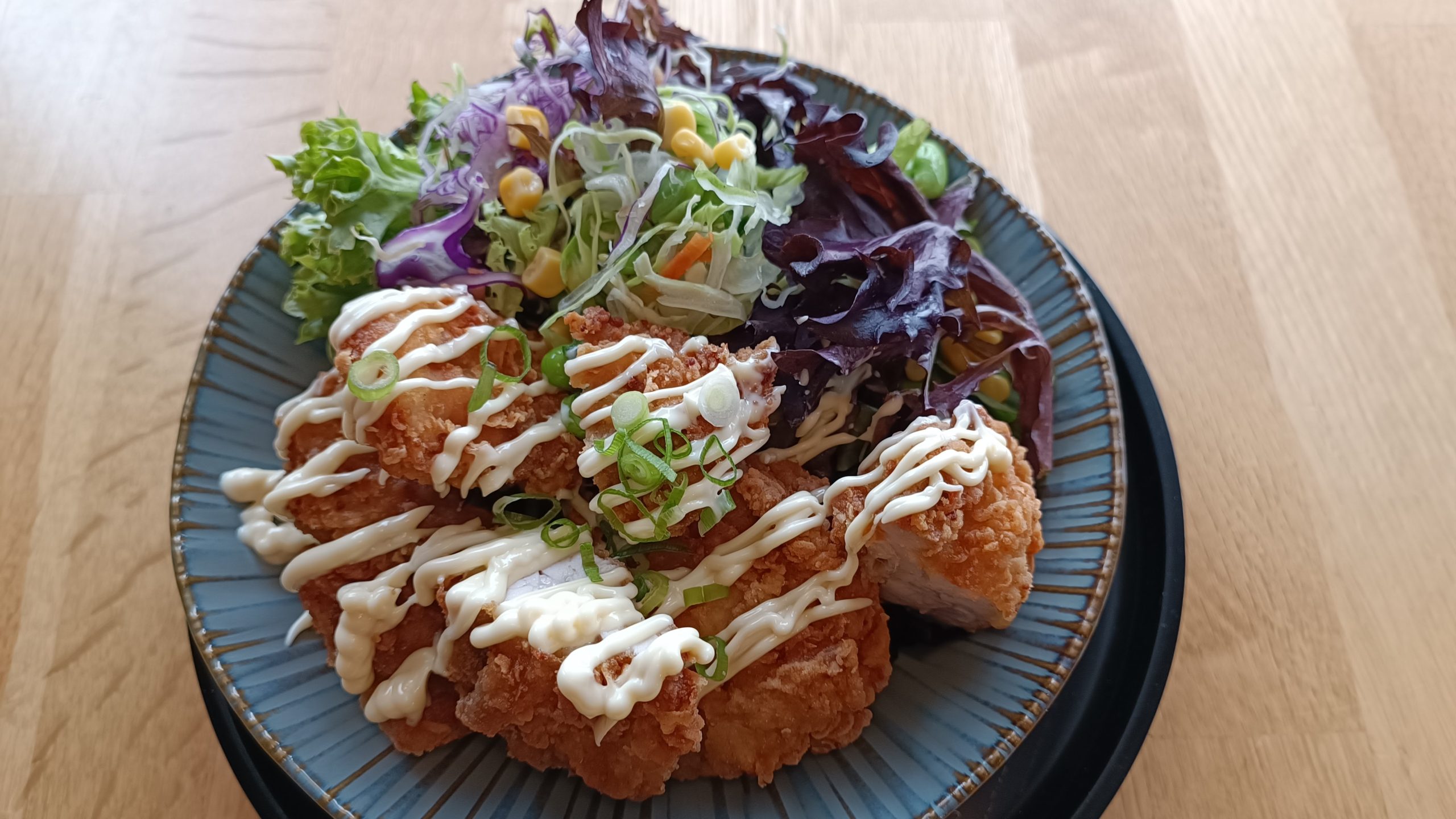 plate of chicken katsu with salad and kewpie mayo drizzle